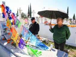 Cerca del mediodía, los pasadizos del Panteón Guadalajara rebosaban de flores de cempasúchil y papel picado. EL INFORMADOR / J. ACOSTA