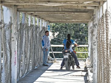 En el puente de la Carretera a Chapala y Guadalupe Montenegro, motociclistas invaden el espacio destinado a los peatones, poniendo en riesgo su seguridad. Mientras tanto, autoridades federales, estatales y municipales se deslindan y se pasan la bolita. Nadie sanciona. EL INFORMADOR/ J. Acosta