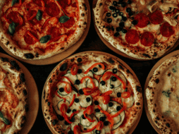 La pizza es un plato italiano, originario de Nápoles; es una base de masa de pan horneada cubierta tradicionalmente con salsa de tomate queso mozzarella y otros ingredientes. CANVA