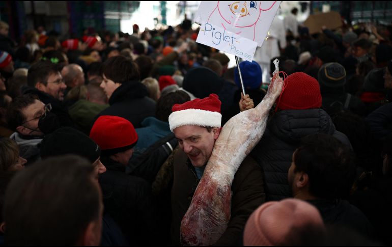 Un cliente se marcha con su compra durante la tradicional subasta de Nochebuena en el mercado de carne de Smithfield, en Londres. AFP / H. Nicholls