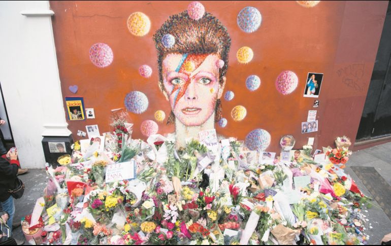 Ofrendas florales se acumularon bajo un mural de David Bowie, pintado por el artista urbano australiano James Cochran (Jimmy C), un día después de anunciarse su muerte, en Brixton, al sur de Londres. AFP
