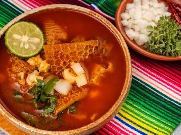 Con el paso del tiempo, el menudo dejó de ser solo un alimento barato para convertirse en un clásico presente en celebraciones y reuniones familiares, y además, la opción fácil y rápida para curar la cruda tras una noche de excesos. ESPECIAL / CANVA e IA