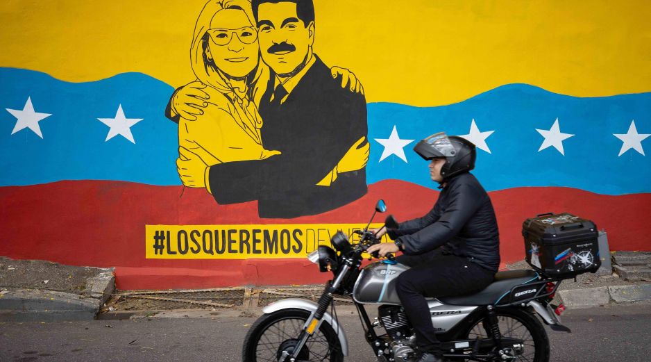 Una persona transita frente a un mural del presidente de Venezuela, Nicolás Maduro, y su esposa, Cilia Flores, en Caracas. EFE/R. Peña