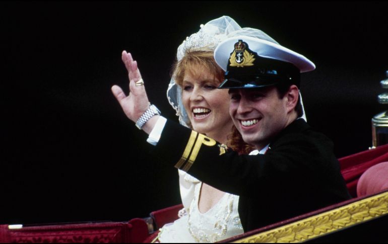El príncipe británico Andrés, junto con su esposa Sarah, saluda desde su carruaje tirado por caballos al salir de la Abadía de Westminster tras su boda en Londres, el 23 de julio de 1986. AP/D. Caulkin