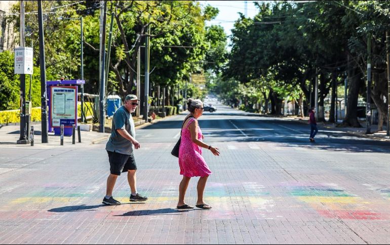 Turistas andan por las calles. Una pareja de visitantes atraviesa una vía en un entorno con tránsito reducido. EL INFORMADOR / A. Navarro