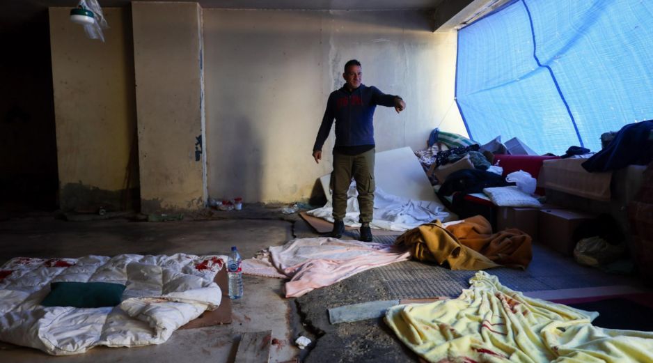 Un hombre libanés desplazado que huyó con su familia del suburbio del sur para refugiarse en un garaje abandonado muestra el lugar donde sus hijos resultaron heridos por las esquirlas de un cohete que impactó en un hotel cercano en un ataque israelí en el distrito de Raouche en Beirut, Líbano, este domingo 8 de marzo de 2026. EFE/W. HAMZEH