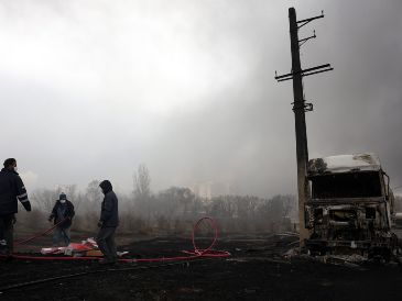 Los iraníes trabajan mientras aún sale humo de la refinería de petróleo de Shahran tras el ataque aéreo de anoche en Teherán, Irán, 8 de marzo de 2026.  EFE/A. TAHERKENAREH