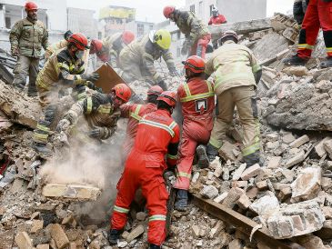 Equipos de rescate buscan a sobrevivientes entre los escombros de un edificio afectado por el bombardeo conjunto entre Estados Unidos e Israel. AP