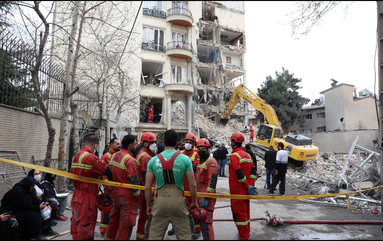 Bomberos y funcionarios iraníes trabajan en el lugar donde se encuentran los edificios residenciales dañados en el norte de Teherán, Irán, el 23 de marzo de 2026. EFE/A. TAHERKENAREH