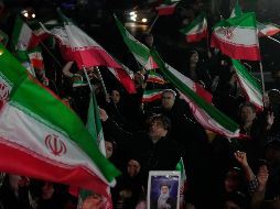 Partidarios del gobierno ondean banderas iraníes durante una manifestación en una plaza. AP/V. Salemi