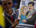 Un hombre sostiene un cartel con la imagen de Nicolás Maduro junto a su esposa, Cilia Flores, durante una manifestación en Caracas. EFE/M. Gutiérrez