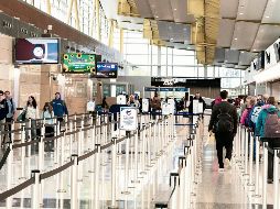 Viajeros transitan por filtros de seguridad con menor afluencia en el Aeropuerto Ronald Reagan de Washington, tras el pago de salarios atrasados a agentes de seguridad, lo que ayudó a reducir filas. AFP