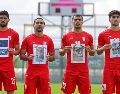 Jugadores iraníes cantan el himno nacional, sosteniendo fotografías de niños presuntamente asesinados en ataques parte de la guerra que EU e Israel sostienen contra Irán. AP / Riza Ozel