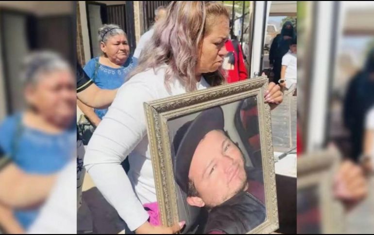 Ceci Flores sostiene una foto de tu hijo durante la misa de este jueves. SUN/ESPECIAL