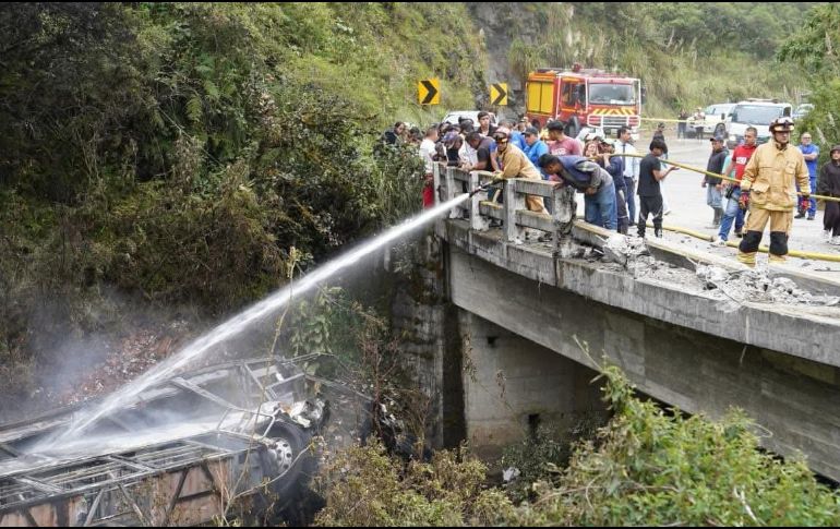 Fotografía cedida por Bomberos Cuenca que muestra a sus integrantes atendiendo el accidente de un autobús que se precipitó a un abismo y posteriormente se incendió. EFE/Bomberos Cuenca
