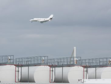 Un avión pasa sobre  instalaciones de almacenamiento de queroseno en el aeropuerto de Lieja, Bélgica. Las aerolíneas advierten de una posible escasez en las próximas semanas y la Unión Europea prepara medidas de emergencia ante las vacaciones de verano. EFE/O. Hoslet