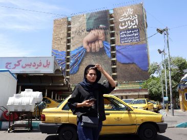 Teherán. Una mujer iraní pasa frente a un cartel con propaganda, que proclama el dominio de ese Gobierno sobre el Estrecho de Ormuz. EFE/A. Taherkenareh