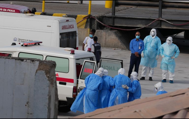 Trabajadores de salud con trajes de protección evacúan pacientes del crucero en una ambulancia en Cabo Verde. AP / M. Apawu
