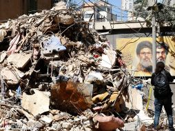 Una mujer pasea por un edificio parcialmente dañado objetivo de un ataque israelí en el barrio de Haret Hreik, suburbio sur de Beirut, Líbano. EFE/STRINGER