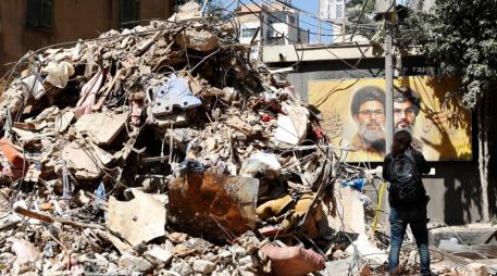 Una mujer pasea por un edificio parcialmente dañado objetivo de un ataque israelí en el barrio de Haret Hreik, suburbio sur de Beirut, Líbano. EFE/STRINGER