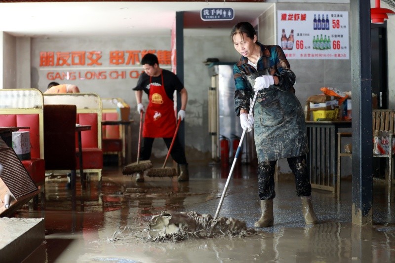 Trabajadores limpian el lodo en un restaurante, en la ciudad de Duyun, en la provincia de Guizhou, en el suroeste de China. XINHUA/X. Wei