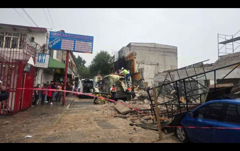 La pared se derrumbó justo sobre un camión de pasajeros y varias unidades que estaban estacionadas o circulando por la zona. SUN/ESPECIAL