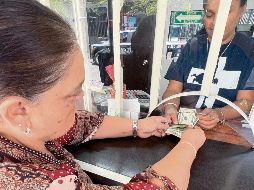 Una mujer cambia dólares enviados desde Estados Unidos, en medio de la incertidumbre por nuevas disposiciones económicas. EL INFORMADOR/ Archivo