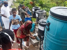 Imagen del 23 de mayo de 2026 de un oficial sanitario (i-atrás) indicando a los pasajeros que llegan que se laven las manos en el punto fronterizo, en Mpondwe, en el oeste de Uganda. Xinhua/N. Kajoba
