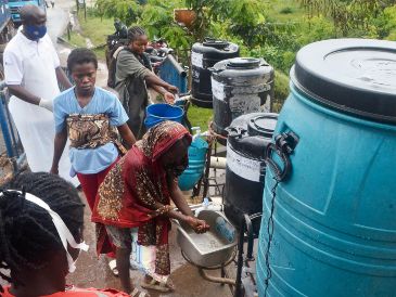 Imagen del 23 de mayo de 2026 de un oficial sanitario (i-atrás) indicando a los pasajeros que llegan que se laven las manos en el punto fronterizo, en Mpondwe, en el oeste de Uganda. Xinhua/N. Kajoba