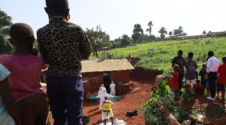 Trabajadores médicos portan trajes de protección mientras son desinfectados previo al entierro de una víctima de ébola, en Mongbwalu, en la provincia de Ituri, en el Congo. XINHUA/STR