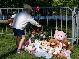 Un niño coloca flores en un altar improvisado en el Parc Ouellette, después de que una niña falleció cuando un castillo inflable fue arrastrado por el viento. AP/C. Muschi