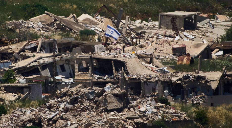 Una bandera israelí ondea sobre un edificio destruido en el sur de Líbano, vista desde el norte de Israel. AP/A. Schalit