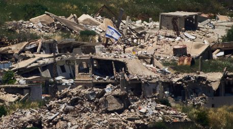 Una bandera israelí ondea sobre un edificio destruido en el sur de Líbano, vista desde el norte de Israel. AP/A. Schalit