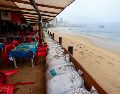 Personas protegen un negocio con costales pesados ante el pronóstico de fuertes lluvias este lunes, en Acapulco. EFE/D. Guzmán