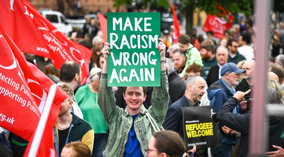 Un hombre sostiene una pancarta que podría traducirse al español como “Haz el racismo malo otra vez”. EFE/M. Hurson