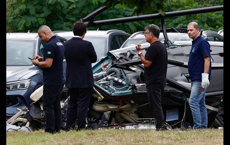Técnicos del Centro de Investigación y Prevención de Accidentes Aeronáuticos de la Fuerza Aérea Brasileña inspeccionan este lunes uno de los helicópteros accidentados en Río de Janeiro. EFE/A. Coehlo