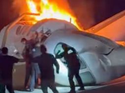 Un pasajero, en la parte superior de la imagen, salta de un avión que se estrelló en una autopista de Texas mientras otras personas ayudan. AP/Z. Garza