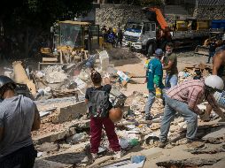 Rescatistas y voluntarios buscan víctimas en una vivienda afectada por los terremotos este jueves, en el municipio Libertador en el este de Caracas. EFE/B. Vergara