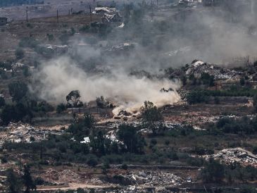 Maniobras de tanques israelíes mientras un convoy de la Fuerza Provisional de las Naciones Unidas en el Líbano (FPNUL) circula entre casas destruidas en la aldea de Meiss El Jabal, en el sur del Líbano, visto desde el lado israelí de la frontera en la Alta Galilea, el 26 de junio de 2026. EFE/A. SAFADI