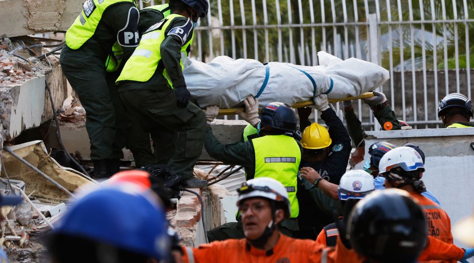 Rescatistas transportan un cuerpo recuperado de los escombros de un edificio derrumbado en Caracas, Venezuela. AP/P. Mattey