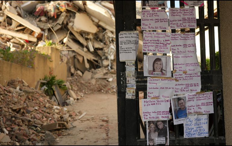 Avisos dejados por familiares que buscan a personas desaparecidas se exhiben en la entrada de un edificio destruido por los terremotos en La Guaira, Venezuela. AP/M. Delacroix