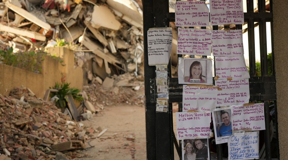 Avisos dejados por familiares que buscan a personas desaparecidas se exhiben en la entrada de un edificio destruido por los terremotos en La Guaira, Venezuela. AP/M. Delacroix