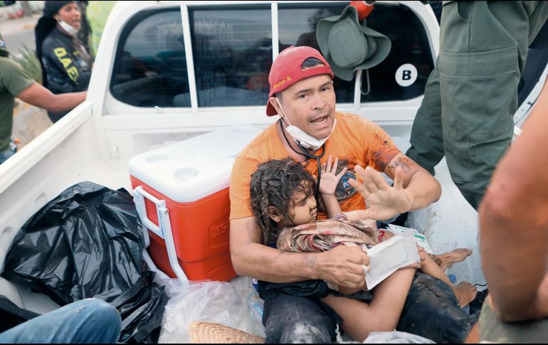 Un rescatista atiende a una niña hallada entre los escombros. AP