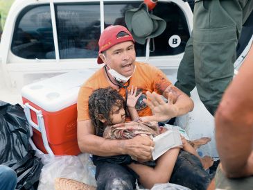 Un rescatista atiende a una niña hallada entre los escombros. AP