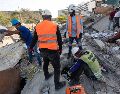 Integrantes de equipos de rescate realizan una búsqueda en los escombros de un edificio este lunes, en La Guaira Venezuela. EFE/ R. Peña