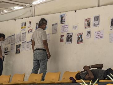 Personas observan listas y fotografías de personas desaparecidas en los terremotos, este lunes, en un puerto en La Guaira, Venezuela. EFE/ Henry Chirinos