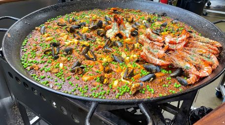 En el Borough Market no existe ni siquiera un espacio con mesas y sillas donde sentarse, y muchos clientes terminan comiendo paella de pie. EFE / L. Campello