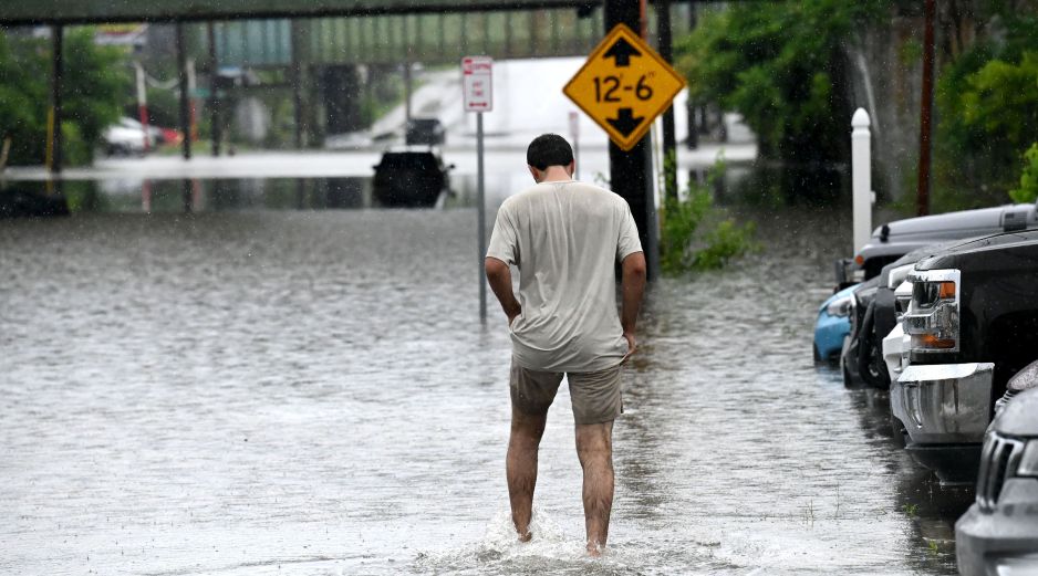 Una persona camina a través de una inundación en Central Avenue cerca de la Interestatal 90. AP/W. Waldron