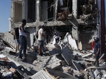 Personas caminan sobre los escombros de un edificio colapsado este lunes, en Cali, Colombia. EFE/E. Guzmán