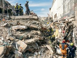 Los rescatistas sacan el cuerpo de una víctima de entre los escombros. AP